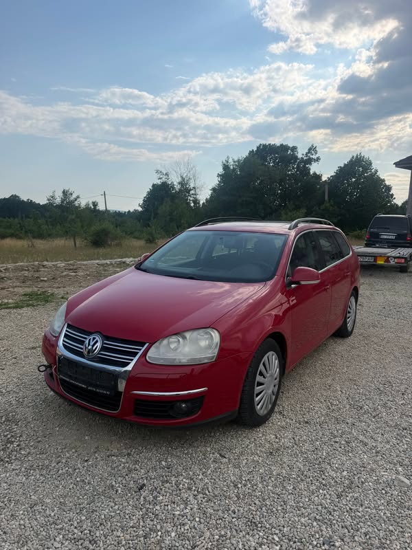 Volkswagen Golf break roșu fotografiat în curte